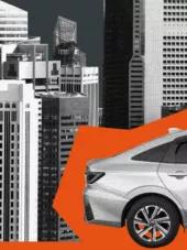 a car in front of black-and-white skyscrapers