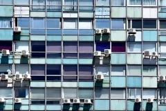 ACs hanging out of windows of tall building
